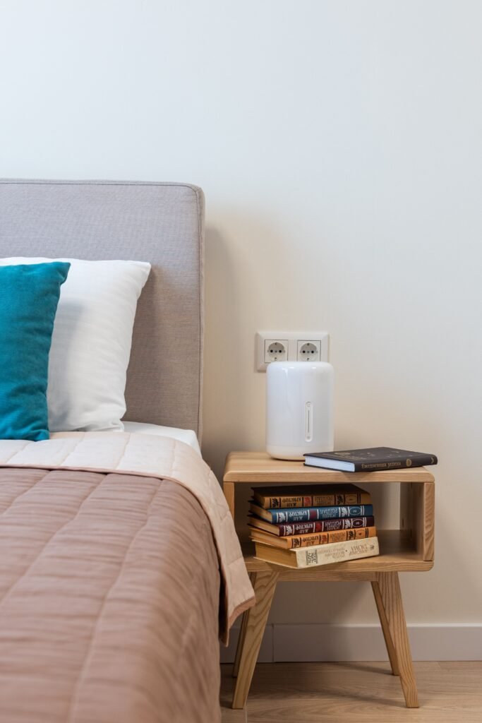 Wooden bedside table with books.