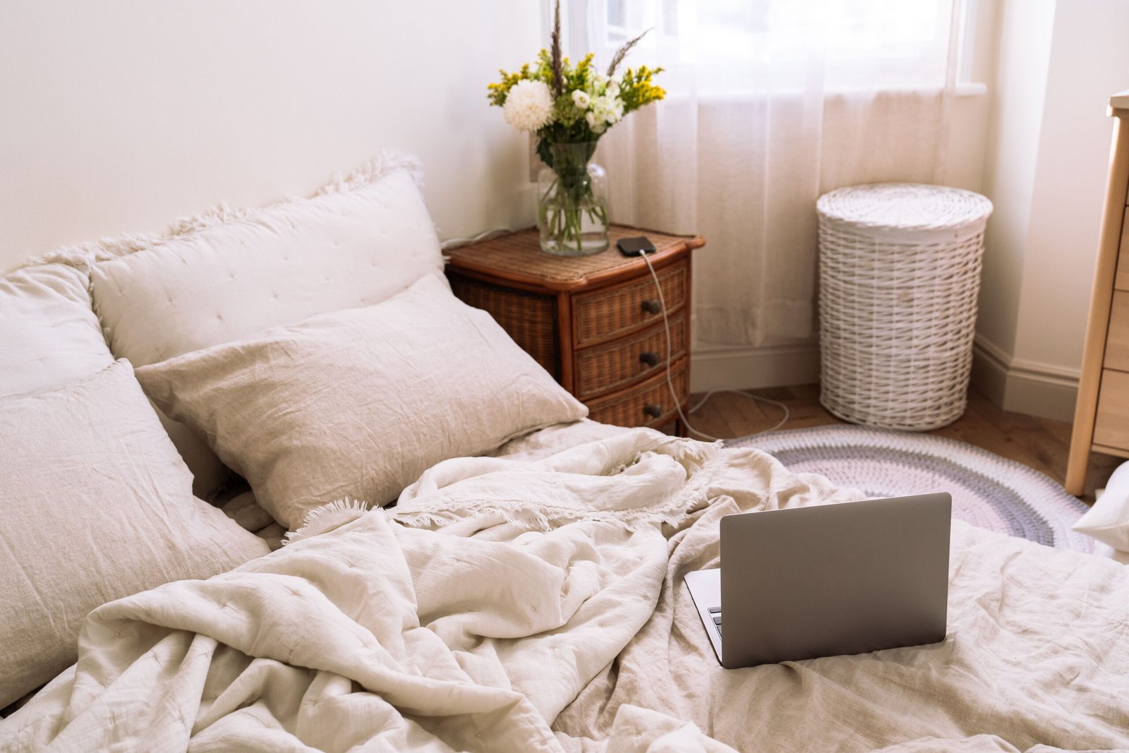 Cosy bedroom with natural bedding and wooden furniture