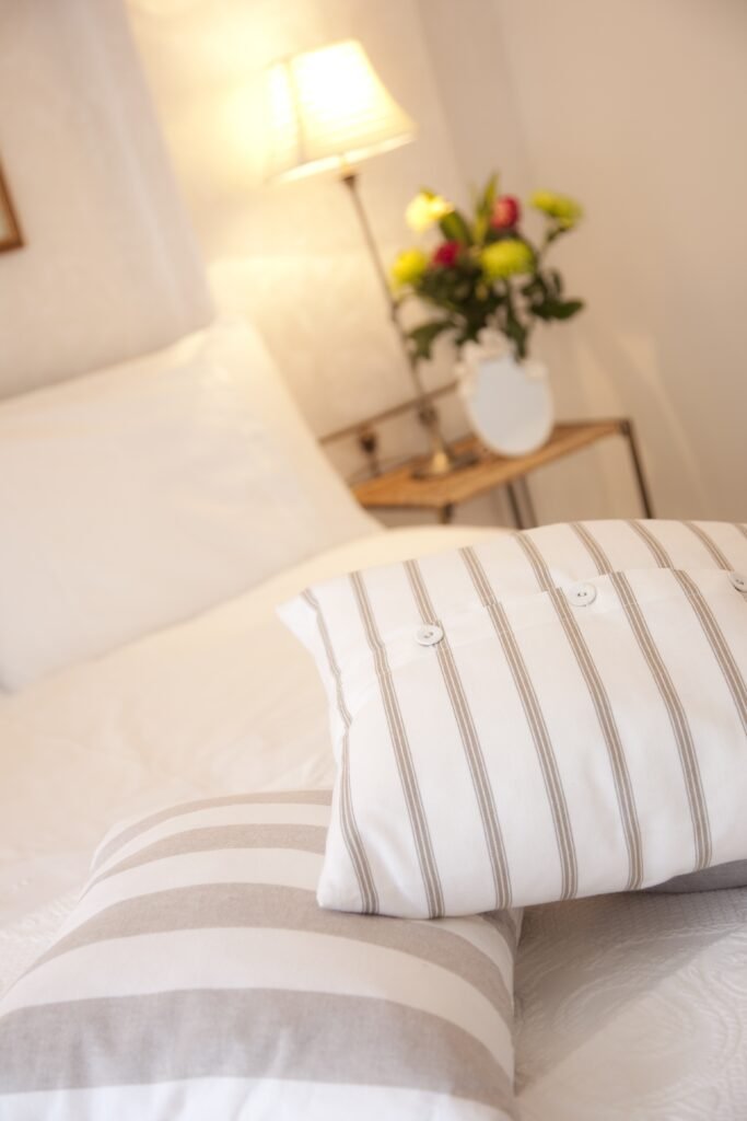 Striped pillowcase on neutral bedding.
